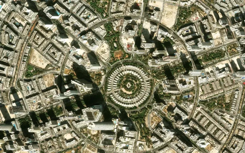 The centre of Jumeirah Village Circle from above: a ring of villas around a park, with apartment towers beyond